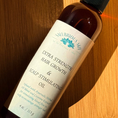 Bottle of Extra Strength Hair Growth & Scalp Stimulating Oil on a wooden surface