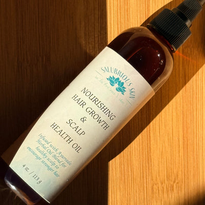 Bottle of nourishing hair growth and scalp health oil on a wooden surface