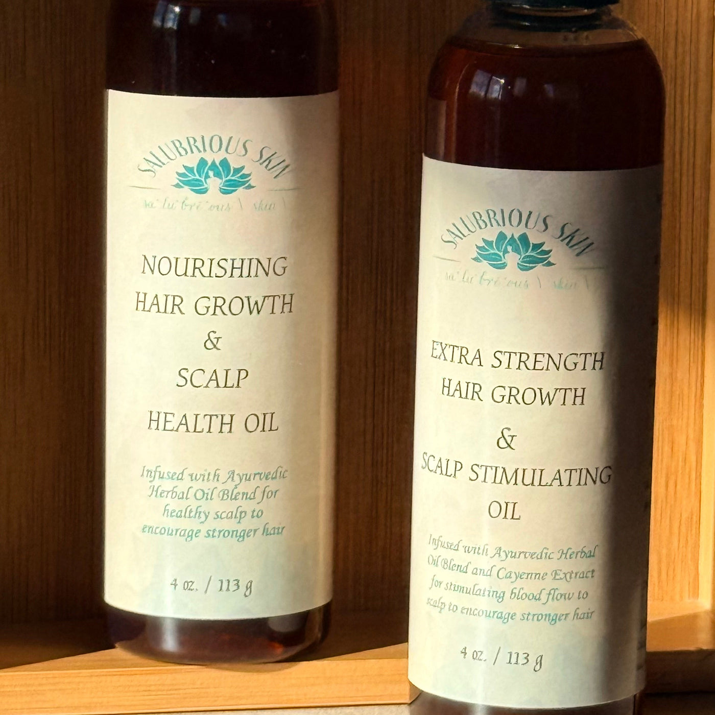 Two bottles of Nourishing Hair Oil on a wooden shelf.
