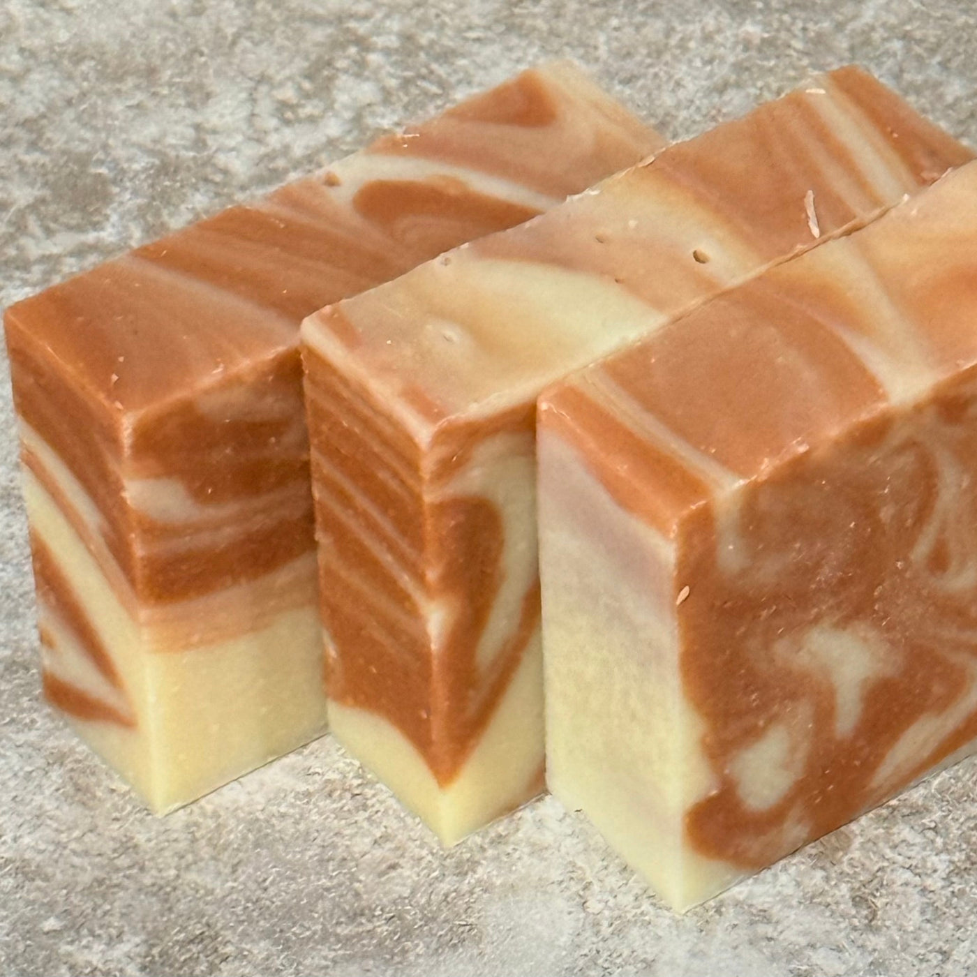 Three swirled soap bars on a textured surface
