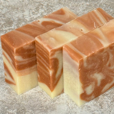 Three swirled soap bars on a textured surface